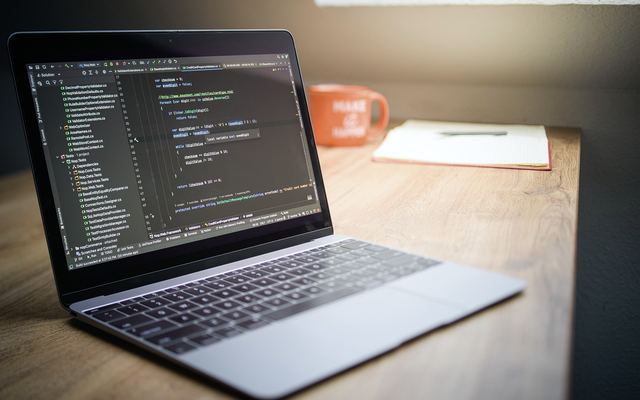 Laptop displaying code on a modern desk